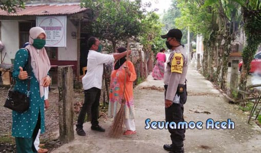 keuchik gampong kuta baro jeuram bersama relawan membagikan 700 lembar masker gratis kepada warga .
